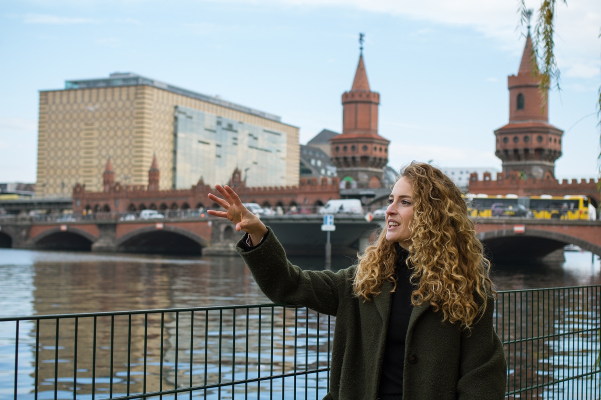 Tina giving a tour by the River Spree with the Oberbaumbrücke in the background