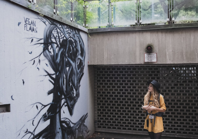 tina standing in front of street art mural